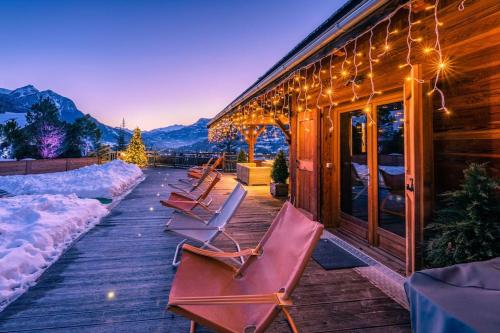 a row of lounge chairs on a wooden deck at CHALET LUXE DE LA CROIX DU FRENE in Briançon