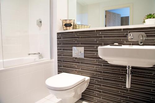 a bathroom with a white toilet and a sink at Azure 7 Apartment in Newquay