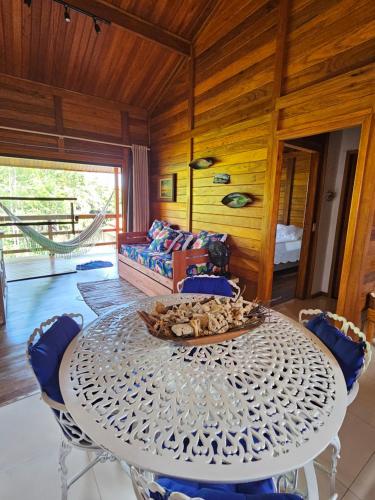 uma sala de jantar com uma mesa branca e cadeiras em Chalé do Beco - Nova Caraíva em Porto Seguro