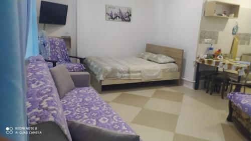 a bedroom with a couch and a bed and a table at Квартира-студия с видом на море in Ureki