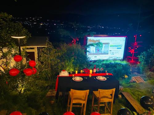 a table with chairs in front of a screen at Nacasoo hill in Tiên Hai