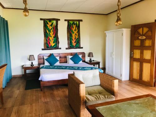 a bedroom with a bed and a chair and a table at Villa Des Flots in La Réunion