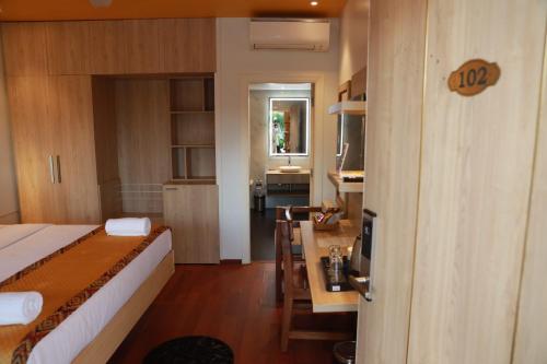 ein Schlafzimmer mit einem Bett und einem Schreibtisch sowie eine Küche in der Unterkunft Gracias Cafe & Resort in Morjim