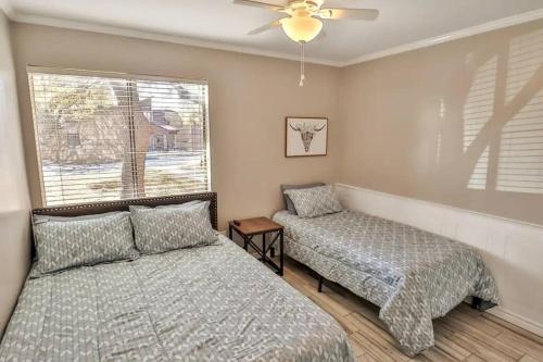 Un dormitorio con dos camas y una ventana. en San Antonio Escape, en San Antonio