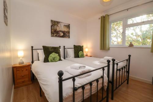 a bedroom with two beds and a window at Walnut House in Lowestoft