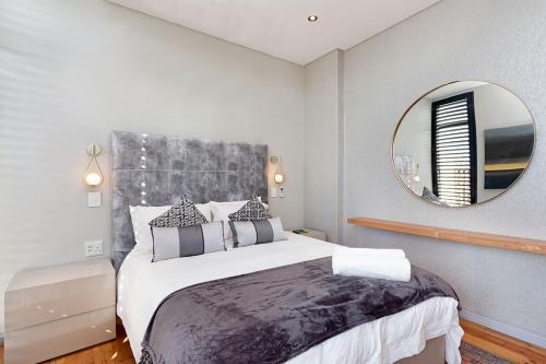 a bedroom with a large bed with a large mirror at Kalkbay Harbour Retreat in Cape Town