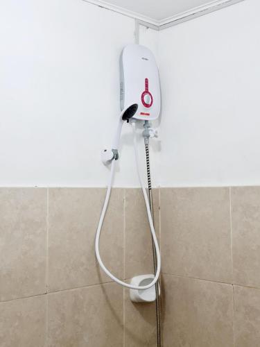 a hair dryer in the corner of a bathroom at Calapan Transient Maple L82 in Calapan