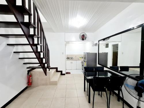 a living room with a staircase and a table and chairs at Calapan Transient Maple L82 in Calapan