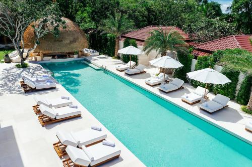 an image of a swimming pool with chairs and umbrellas at Zazen Boutique Resort & Spa - SHA Plus in Bophut 