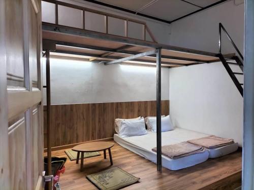 a bedroom with two bunk beds and a table at E HOME 2 KULAI-Tatami house in Kulai