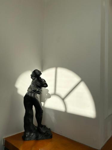 a statue of a dog with a shadow of a clock at HAKONE DOMA in Hakone