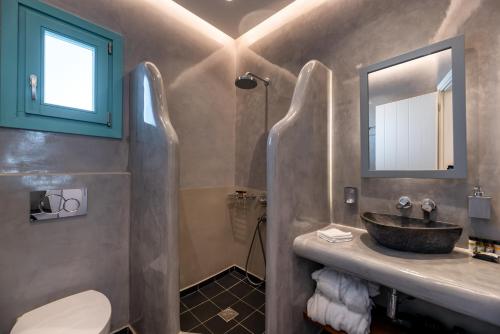 a bathroom with a sink and a mirror at Santa Irina Luxury Sunny Lofts in Perivolos