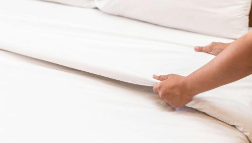 a person laying on top of a white bed at Georgetown Lodge in Georgetown
