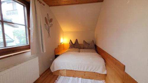 a small bed in a small room with a window at Knaller der Reiterbauernhof in Reisach