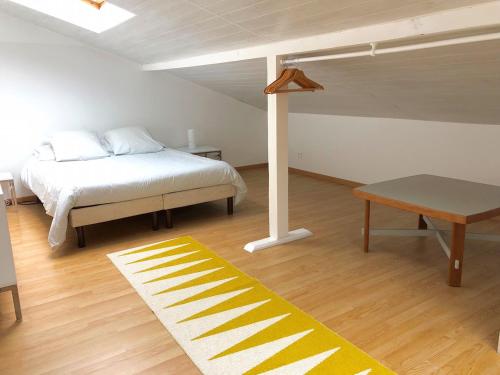 a bedroom with a bed and a table and a rug at Le Loft des Musiciens in Mulhouse