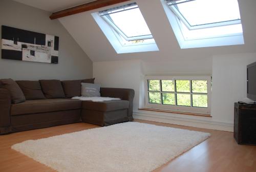 a living room with a couch and two windows at The Little House in Beersel