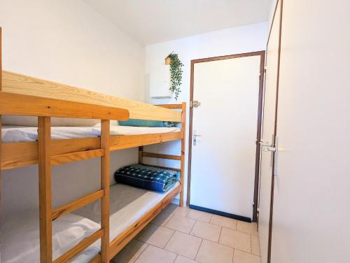a room with two bunk beds and a door at Appartement au CALME + parking in Cap d'Agde