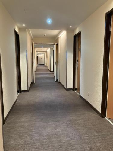 un couloir d'un immeuble de bureaux avec un long couloir dans l'établissement SleepBEEONE AIRPORTHOTEL FRANKFURT MÖRFELDEN, à Mörfelden-Walldorf