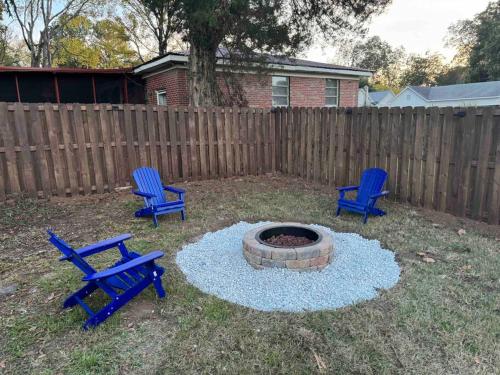 two blue chairs and a fire pit in a backyard at Harris Home in Birmingham