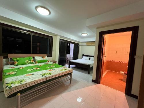 - une chambre dotée d'un grand lit avec des draps verts dans l'établissement Hideaway House Patong, à Patong Beach