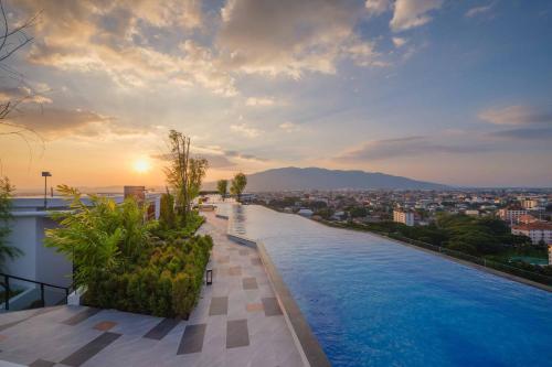 a pool on the roof of a building with a city at Luxury Astra Sky River in Chiang Mai