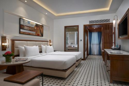a hotel room with a large bed and a desk at Radisson Blu Resort, Goa in Cavelossim