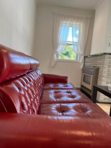 a leather couch in a living room with a window at HAKONE DOMA in Hakone