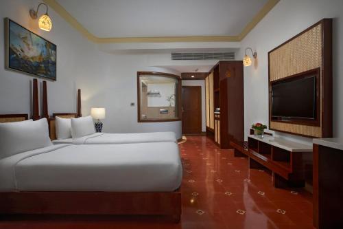 a hotel room with a bed and a flat screen tv at Radisson Blu Resort, Goa in Cavelossim