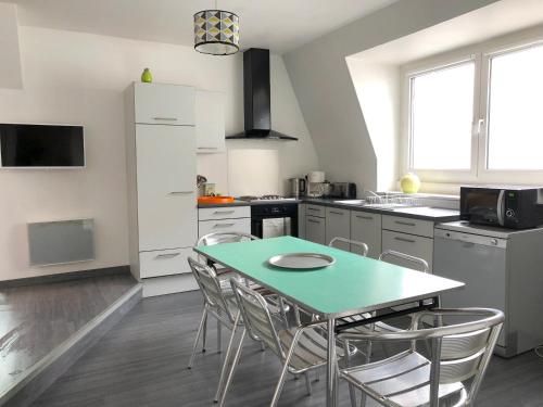 une cuisine avec une table et des chaises dans l'établissement Le Loft des Musiciens, à Mulhouse