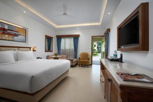 a hotel room with a bed and a television at Radisson Blu Resort, Goa in Cavelossim
