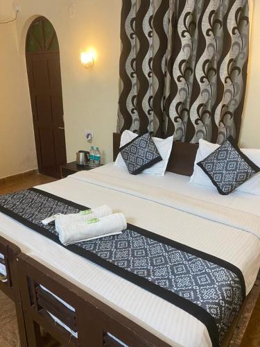 a bedroom with a bed with a large headboard at Baga Beach Crystal in Baga