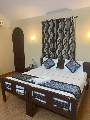 a bedroom with a large bed with a large headboard at Baga Beach Crystal in Baga