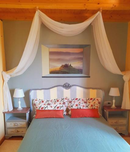 una camera con letto blu a baldacchino di VILLA DEI TRAMONTI a Gavirate