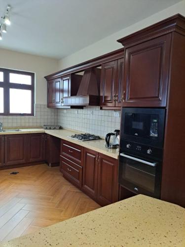 a kitchen with wooden cabinets and a stove top oven at Marique villa in Mombasa