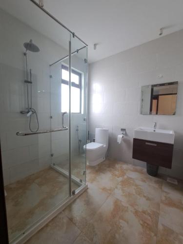 a bathroom with a shower and a toilet and a sink at Marique villa in Mombasa