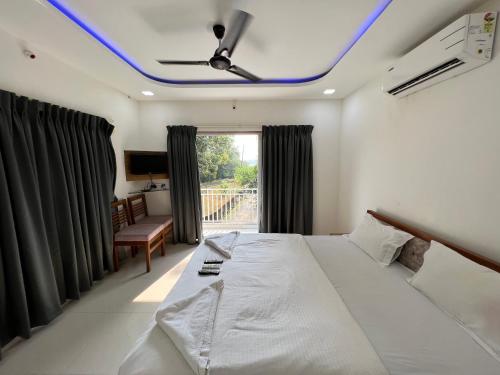 a bedroom with a bed with a ceiling fan at iIRA Stays-Sea Coast Farm in Alibaug