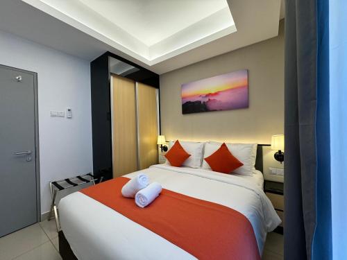 Schlafzimmer mit einem Bett mit orangefarbenen und weißen Kissen in der Unterkunft The Minnook Suites, Genting Highlands in Genting Highlands