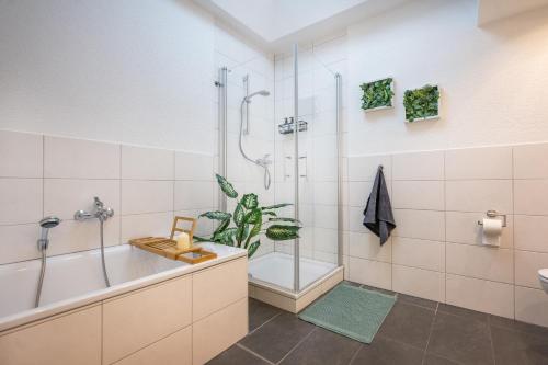 y baño con ducha, bañera y lavamanos. en 140qm 3BR apartment - central, cozy and stylish, en Coblenza