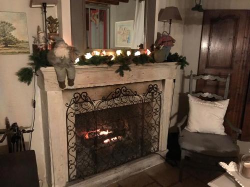 a fireplace with christmas lights on top of it at Le Clos Fanny chambre d’hôtes 