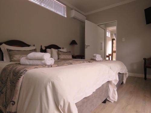 Un dormitorio con una gran cama blanca con toallas. en Jedidja Bed and Breakfast, en Bloemfontein