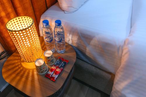two bottles of water on a table next to a bed at House 76 in Nizwa