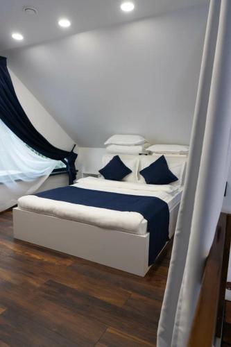 ein Schlafzimmer mit einem großen Bett mit blauen Kissen in der Unterkunft Коттедж «Большая станица» in Almaty