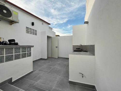 cocina con paredes blancas, encimera y fregadero en Morgan apartamentos Marbella centro en Marbella