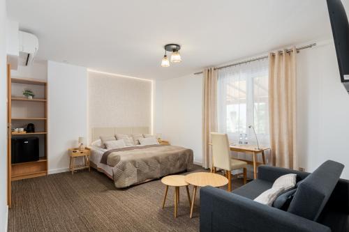 sypialnia z łóżkiem, kanapą i stołem w obiekcie Hotel Łaziska w mieście Czchów