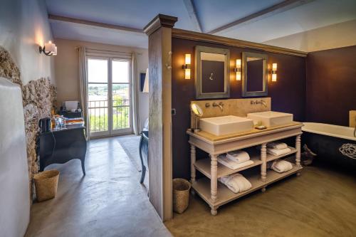 a bathroom with a sink and a mirror at La Bastide Du Clos des Roses - Teritoria in Fréjus