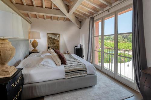 een slaapkamer met een bed en een groot raam bij La Bastide Du Clos des Roses - Teritoria in Fréjus