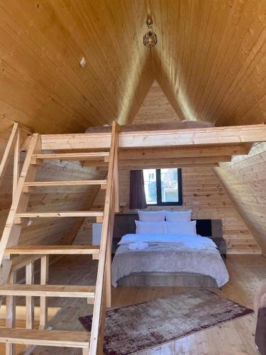 Cama elevada en habitación de madera con cama en Twin cottages kazbegi 2 en Kazbegi