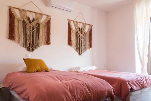 two beds in a room with curtains on the wall at Increíble Duplex luminoso, plaza del Aymto. in Talavera de la Reina