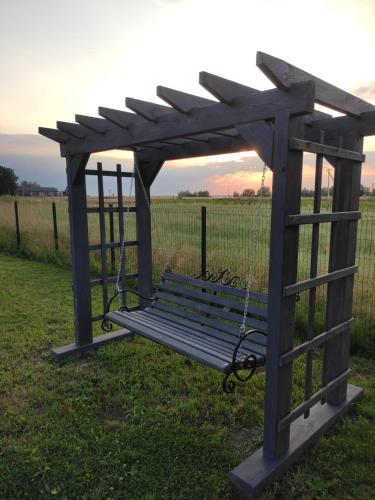 a park bench with a pergola in a field at Сімейний куточок in Svityazʼ
