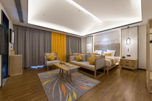 a hotel room with a bed and a couch at Mengjing Xiyue Hotel in Kunming